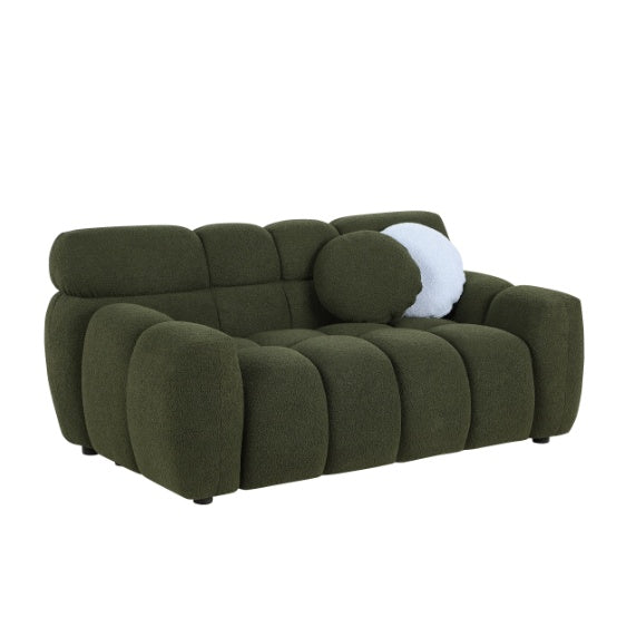 Green upholstered sofa bed with unique boucle fabric and a decorative round pillow.